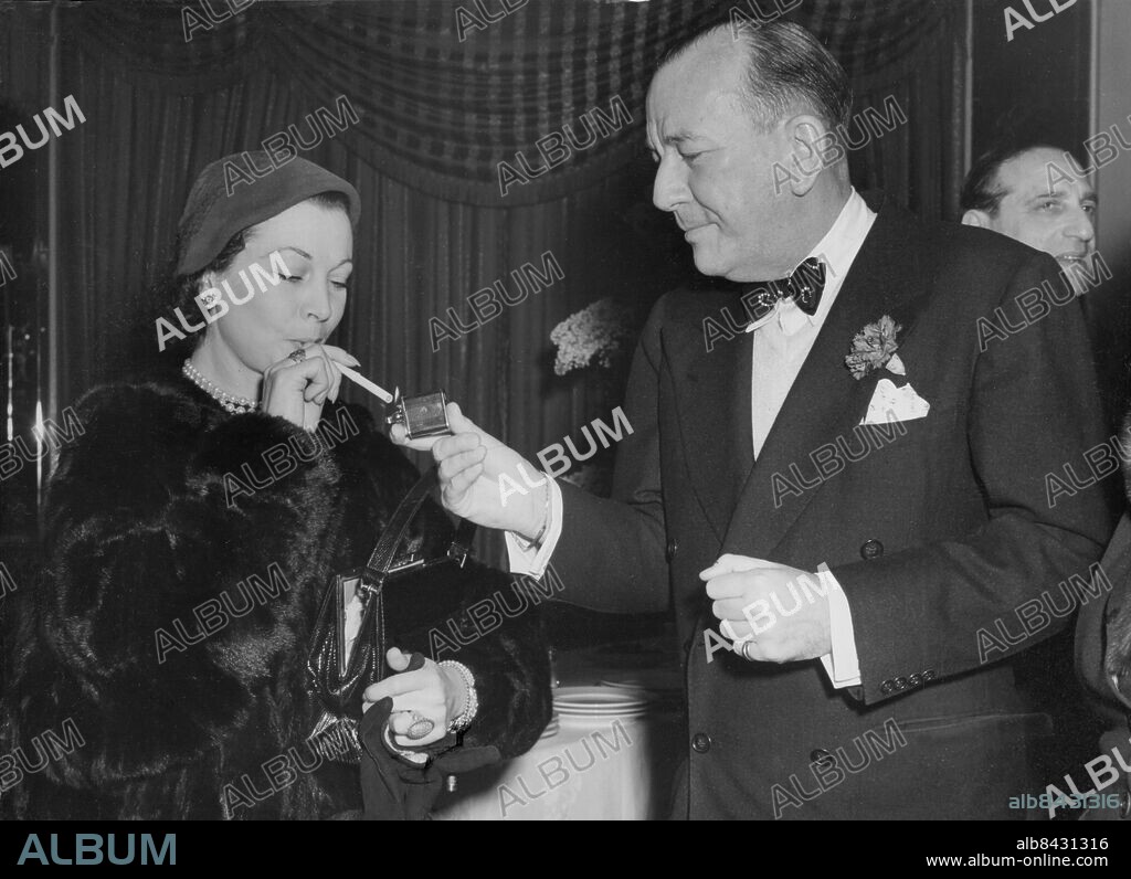 Orig. bildtext... STARS COMBINE TO LAUNCH CHARITY SHOW In the Orchid Room at the Dorchester Hotel today, Noel Coward lights a cigarette for Vivien Leigh before a buffet luncheon to launch the combination of the charities of the Actors' Orphanage and the Jewish National Fund today. They plan to hold a midnight matinee Stars At Midnight at the Palladium on May 28th. Anm. N Coward, 1899-1973, engelsk skådespelare och författare V Leigh, 1913-1967, engelsk skådespelare Cigarettändare Artig Fluga Gentleman Tända en cigarett CD426 persons: NOEL COWARD;VIVIEN LEIGH sites: LONDON;STORBRITANNIEN.