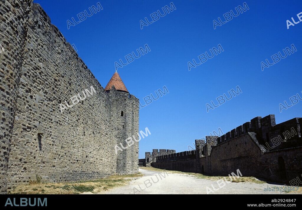 France. Aude department. Occitanie region. Cite de Carcassonne. Medieval citadel. The architect Euge_ne Viollet-le-Duc renovated the fortress (1853-1879). View of the double defensive wall, separated by lices (parapet walk).