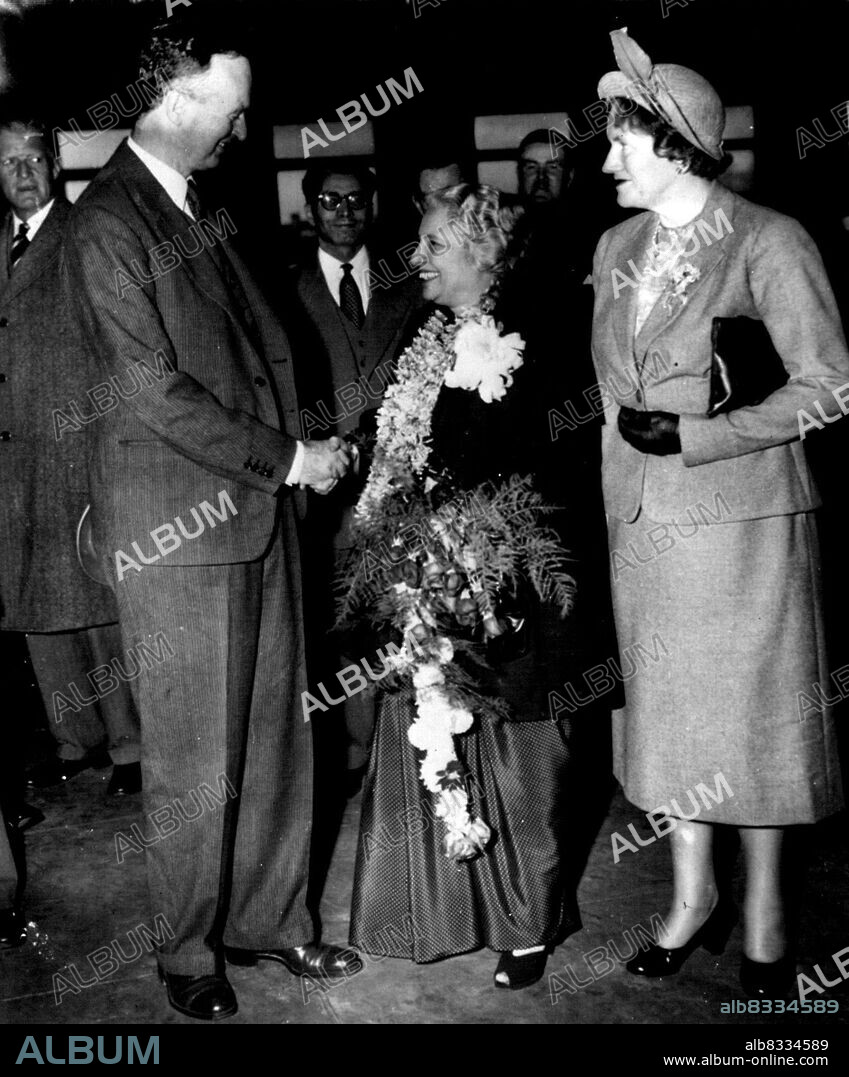 Goodbye To Madame Pandit - Madame Vijava Lakshmi Pandit, India's retiring ambassador, wears and carries farewellflower gifts as she receives a goodbye and a handshake from Sir Oliver Franks, British ambassador, at Union station this evening. Mrs. Franks (right) is with them, John Simmons (left background, state department protocol chief, represented the U.S. as Mme. Pandit left for New York on her way home. She will become a candidate for parliament in India's first constitutional election. November 15, 1951. (Photo by AP Wirephoto).