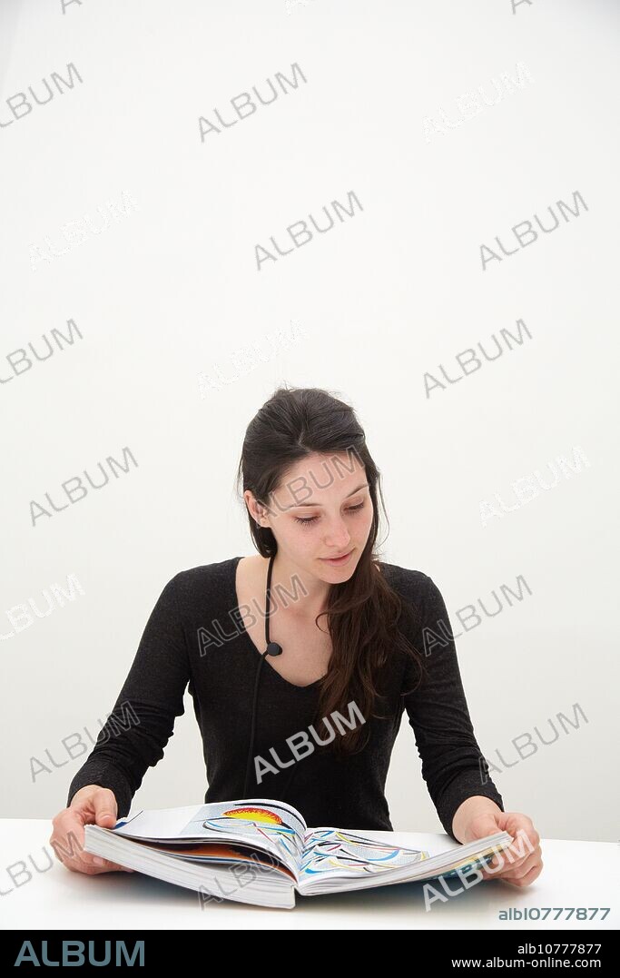 Young woman looking at exhibition catalog. David Hockney, ´A Bigger Picture´ exhibition, Guggenheim Museum, Bilbao, Biscay, Basque Country, Spain.