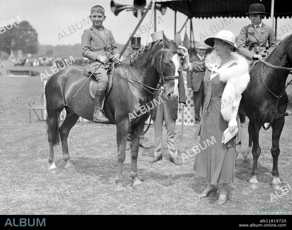 Richmond horse show. Master Philip Gardner on "Joby" receiving first prize in children's jumping class from princess Alice countess of Athlone. 1933.