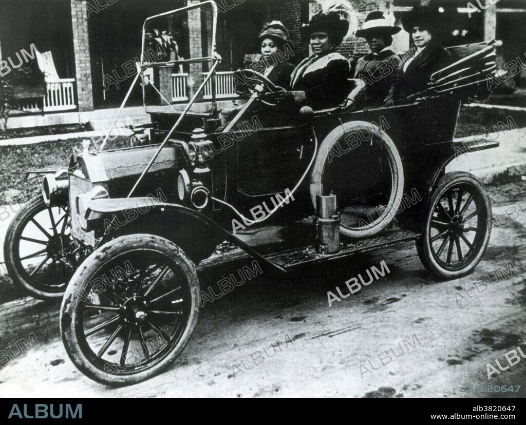 Madam Walker at the wheel with friends, 1916. Sarah Breedlove (December 23, 1867 - May 25, 1919), known as Madam C. J. Walker, was an African-American entrepreneur and philanthropist, regarded as the first female self-made millionaire in America. During the 1890s, Walker began to suffer from a scalp ailment that caused her to lose some of her hair. She experimented with homemade remedies and store-bought products. She moved to Denver to work on her hair care products, and married Charles Joseph Walker, a newspaper advertising salesman. She emerged with the name Madam C. J. Walker, an independent hairdresser and retailer of "Madam Walker's Wonderful Hair Grower," a scalp conditioning and healing formula, which she claimed had been revealed to her in a dream. In 1906, she put her daughter A'Lelia in charge of the mail order operation while she and her husband traveled throughout the southern and eastern United States to expand the business. She began to teach and train other black women in women's independence, budgeting, and grooming in order to help them build their own businesses. She also gave lectures on political, economic and social issues at conventions sponsored by powerful black institutions. She died in 1919, from complications of hypertension, at the age of 51.