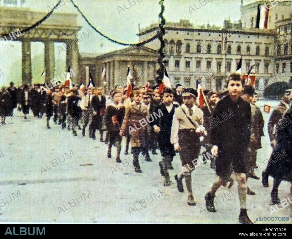 german school children march with Nazi flags through the brandenburg Gate in Berlin. Circa 1933-35.