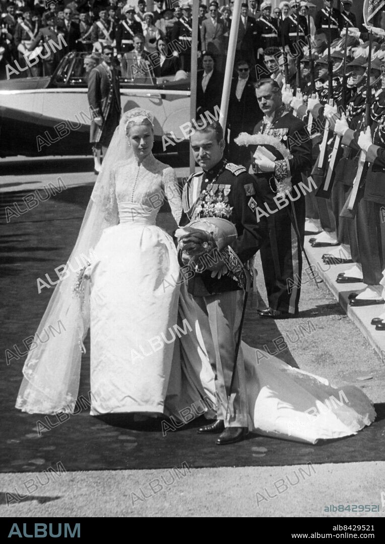 Orig. bildtext... THE CATHEDRAL WEDDING Grace Kelly and prince Rainier were married in the Roman Catholic Cathedral of Monaco today, a day full of splendour and glory for the bride and bridegroom and the many thousands of monagasques and visitors who eighter watched the cathedral ceremony or the drive through the streets. Photo shows. The wedding ceremony over, prince and princess turn to look back at the cathedral before passing through the guard of honour which included men of the Royal Navy. Anm. Brudar Brudgummar Klänningar Bröllopsklänningar persons: GRACE, FURSTINNA AV MONACO;RAINIER, FURSTE AV MONACO;GRACE KELLY sites: USA*;MONACO.