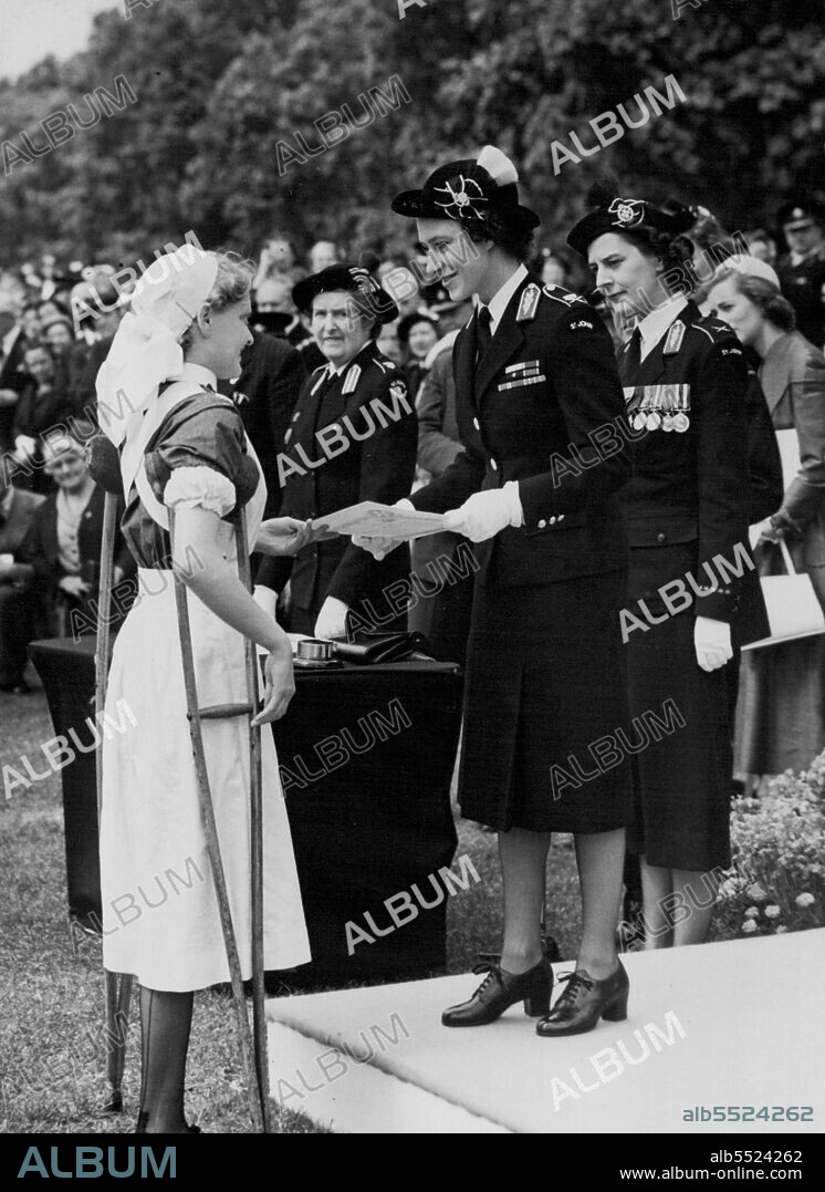 Resting on her crutch, eighteen-year-old cadet Barbara Goodyear receives a St. John's Ambulance Brigade certificate from her Commandant-in-chief Princess Margaret. Barbara who used to wear a surgical boot broke her afflicted leg and she had to choose between total disablement - or amputation, Barbara chose the latter so that she could follow her nursing career.
The certificate was presented to her yesterday in Hyde Park at a parade of 7,000 of the St. John Ambulance Brigade. July 26, 1954. (Photo by Daily Mirror).