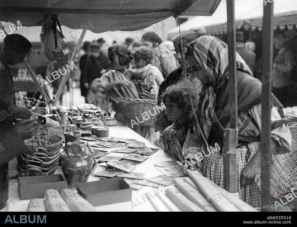 FRANKRIKE SAINTES-MARIES-DE-LA-MER omkring 1930. Orig. bildtext... ZIGEUNER WALLFAHRTEN. DIE MADONNA DER NOMADEN. Im Bazar vor der Kirche. Hier sind Bilder der beiden Marien zu kaufen. Foto: Presse-Photo / AB Text & Bilder / SVT / kod:5600 Mapp: Zigenare 3946 C 5 Bildserier Fotoreportage Vallfartsorter Pilgrimsorter Sara La Kali - Svarta madonnan - romernas skyddshelgon i Saintes-Maries-de-la-Mer sites: FRANKRIKE;SAINTES-MARIES-DE-LA-MER PhotoDate:193?-??-??.