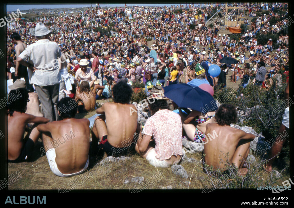 Manifestation au plateau du Larzac.. Photographie de 1974.. La lutte du Larzac (Aveyron) a debute le 28 octobre 1971. Michel Debre, ministre de la  Defense a l'epoque, annonce l'extension d'un camp militaire de 3.200 à 14.000 hectares pour entrainer les divisions blindees et les engins lance-missile. Les agriculteurs, opposes a ce projet, s'organisent alors autour du 'serment des 103', pacte reunissant 103 agriculteurs qui s'engagent a refuser de vendre leurs terres a l'armee. Pour soutenir la cause des 103 agriculteurs, une manifestation s'organise en 1974 rassemblant 100 000 qui clament leur slogan : 'Le ble fait vivre, les armes font mourir'.. Credit : Photo Kharbine-Tapabor.