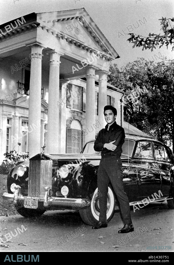 Oct. 13, 1960 - Memphis, TN, U.S. - Elvis Presley and his Rolls Royce in October, 1960. Back home after a stint of movie making in Hollywood, Elvis proudly posed with the latest mark of his fame as the king of rock and roll - a brand new black Standard Salon Silver Cloud II Rolls Royce worth some 8,000. Despite his aversion to flying, the teenage idol landed at Municipal Airport, Monday afternoon, Oct. 10, 1960, with little fanfare and went directly to his Graceland estate, where he will take it easy about a month before going back to Hollywood for another film. ( By Robert Williams / The Commercial Appeal ) NOTE: published friday, Oct. 14, 1960. 13/10/1960