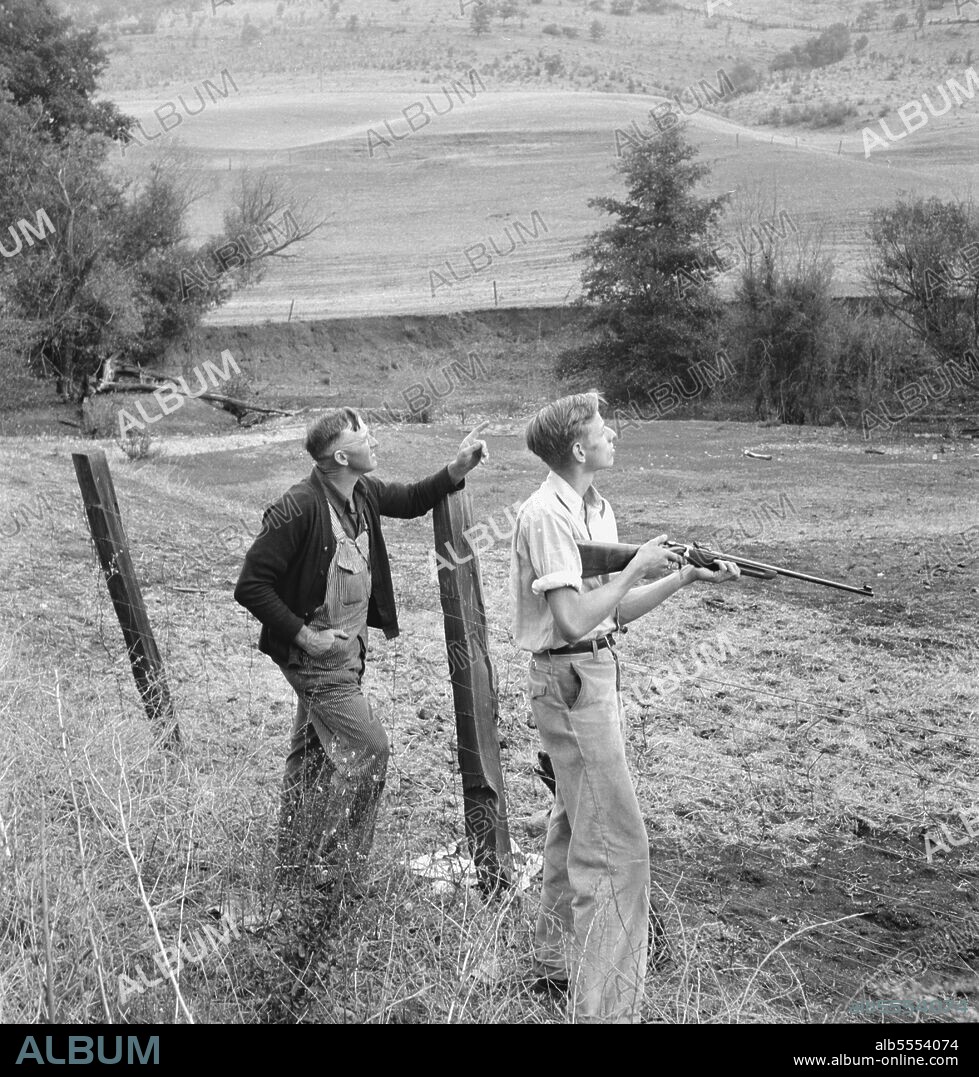 DOROTHEA LANGE. Farmer and boy in the fall of the year at the time the hunting season opens. They live in a white painted house across the road. Jackson County, Oregon.