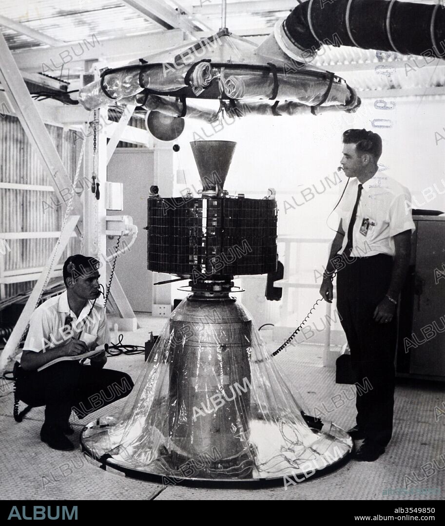 Photograph of Syncom 2 - Technicians check the mating of the Syncom communications satellite atop the third stage of the Delta launch vehicle at Cape Canaveral, Florida. Dated 20th century.