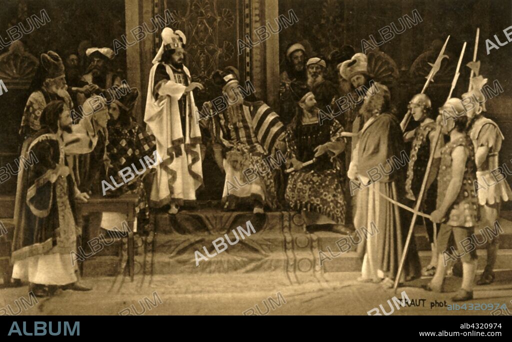 HENRY TRAUT. Jesus before the Sanhedrin, 1922. Jesus (Anton Lang) is tried before an assembly of rabbis: players in the Oberammergau Passion Play. The play is performed every 10 years, on open-air stages, by the inhabitants of the village of Oberammergau in Bavaria, Germany. First staged in 1634, the play tells the story of Jesus' passion, culminating in his crucifixion. The event has become a tourist attraction, with audiences coming from all over the world. Official postcard of the 1922 Oberammergau Passion Play. [F. Bruckmann, Munich, Germany, 1922].