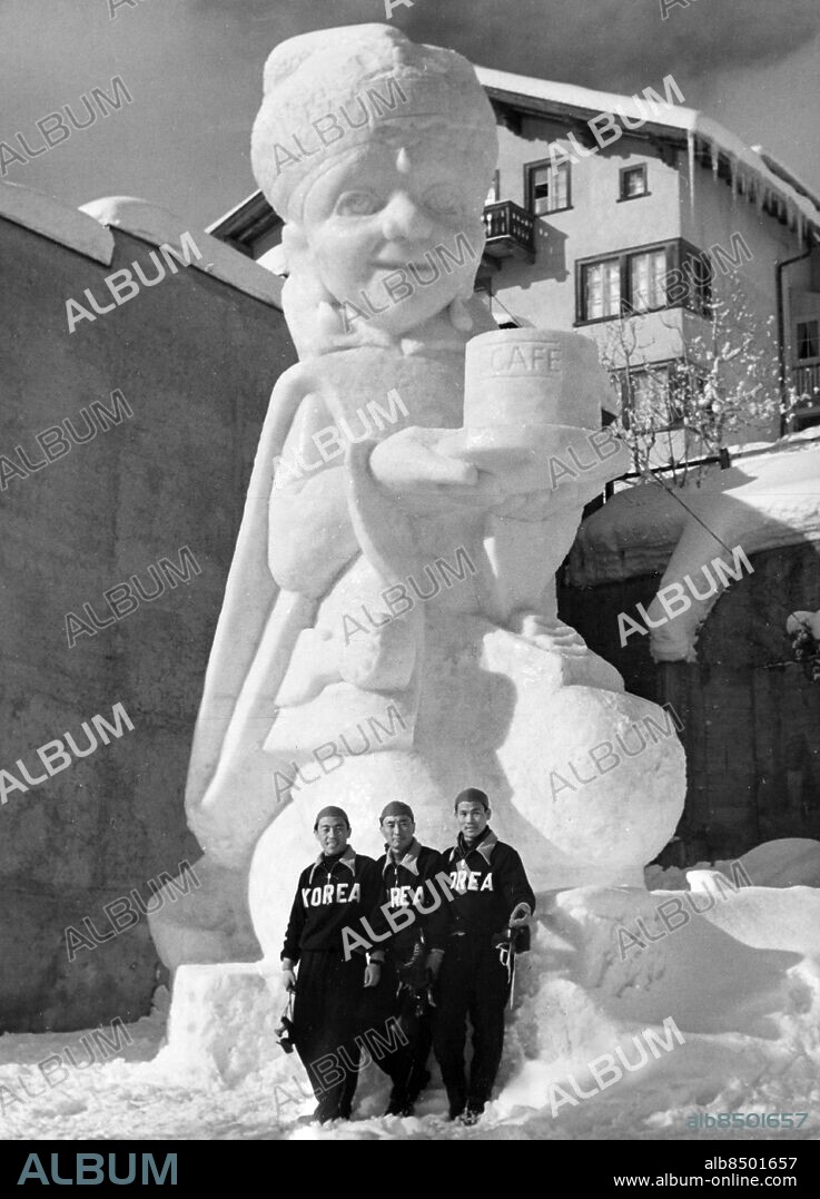 SCHWEIZ SANKT MORITZ 1948-01.. S:t Moritz största snöskulptur, den 10 meter höga Alijawa, står nu klar inför de olympiska vinterspelen 1948. Skulptören Jacques Leutenegger har arbetat med konstverket i drygt fjorton dagar. Här ses de koreanska skridskolöparna fotograferade framför snöskulpturen.. Foto: AB Text & Bilder / SVT / Kod: 5600. Mapp: Vinterolympiaden i S:t Moritz: Diverse kringbilder I:271A. Skulpturer.