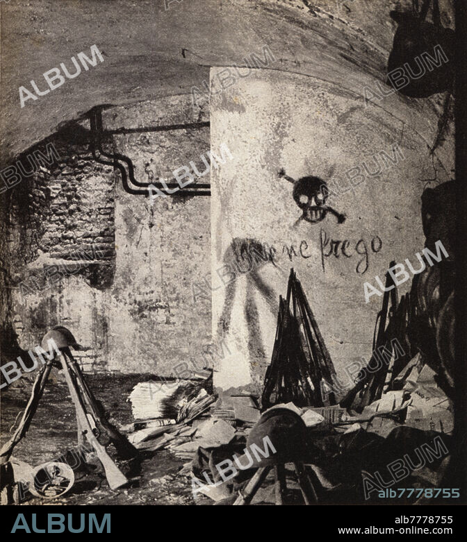 FASCISM The dungeons of the "Covo", the usual bivouac of the armed guard of "Il Popolo d'Italia", which had its first seat on the upper floors; on the back wall the slogan appears: "Me frego" coined by Benito Mussolini. After the transfer of the newspaper to via Lovanio, the "Covo", transformed into a permanent museum of the "Fascist Revolution", was proclaimed "national monument" starting from November 15th 1939, and then the seat of the "School of fascist mysticism Sandro Italico Mussolini" , founded by Niccolò Giani (20 June 1909 - 14 March 1941) together with a group of GUF students with the aim of training future leaders of the National Fascist Party. Photo illustration from: "The lair of Via Paolo da Cannobio. November 15th 1914 - November 15th 1920", publication by the "School of Fascist mysticism Sandro Italico Mussolini", second special edition of 2000 numbered copies, copy n. 566. Layout by Giuseppe Pagano (Giuseppe Pogatschnig, 20 August 1896 - 22 April 1945, former graphic designer of the newspaper), graphic design by the Raffaello Bertieri Institute. Italy, Milan 1940.