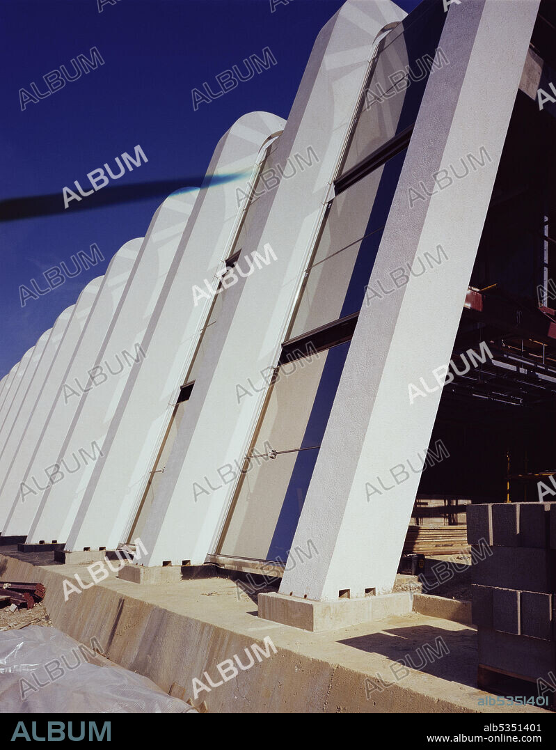 JOHN LAING PLC. A close-up of the sloping precast concrete columns and structural glass at Napp Laboratories. Napp Laboratories was built by Laing Management Contracting for Napp Pharmaceutical Group, with work starting in October 1980. The building project included a combined pharmaceutical production building and warehouse, research and laboratory services, administration offices, restaurant and auditorium. The building, which was designed by Toronto-based Arthur Erickson Architects, consists of three buildings linked together to form one complex. Sitting 1200 mm above the surrounding land on a concrete podium, it also has an ornamental lake on the south side. It was constructed using 102 sloping precast concrete columns and solar reflective sloping double glazing known as structural glazing.