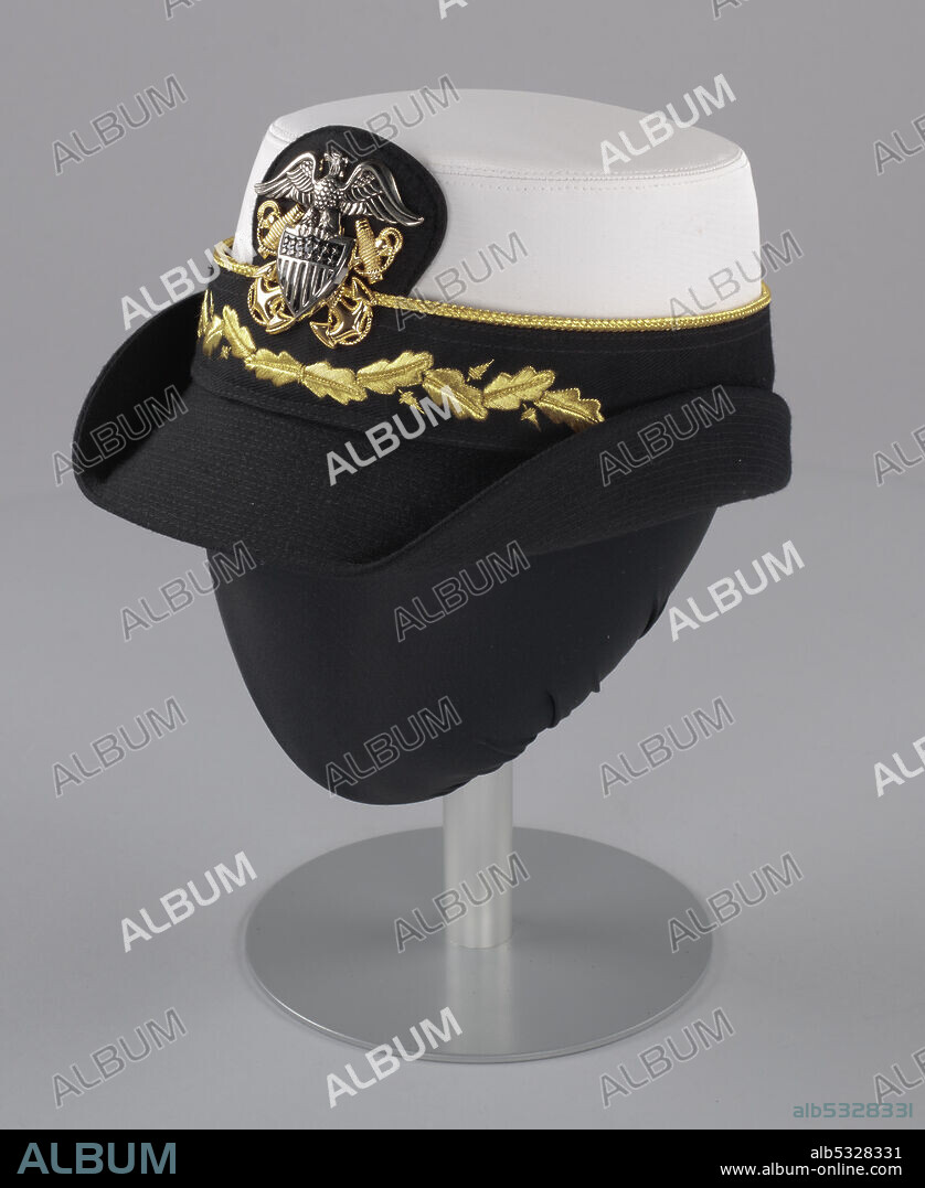 INC KINGFORM CAP COMPANY. Four-star Admiral Michelle Howard (born 1960) was the first African-American woman to command a United States Navy ship. In 2014 she was appointed Vice Chief of Naval Operations, the second highest ranking officer in the US Navy. A US Navy dress uniform hat (a) worn by Admiral Michelle Howard as commander with a white waterproof fabric crown and a black canvas brim, with a hat band (b) featuring a US Navy insignia pin (c).