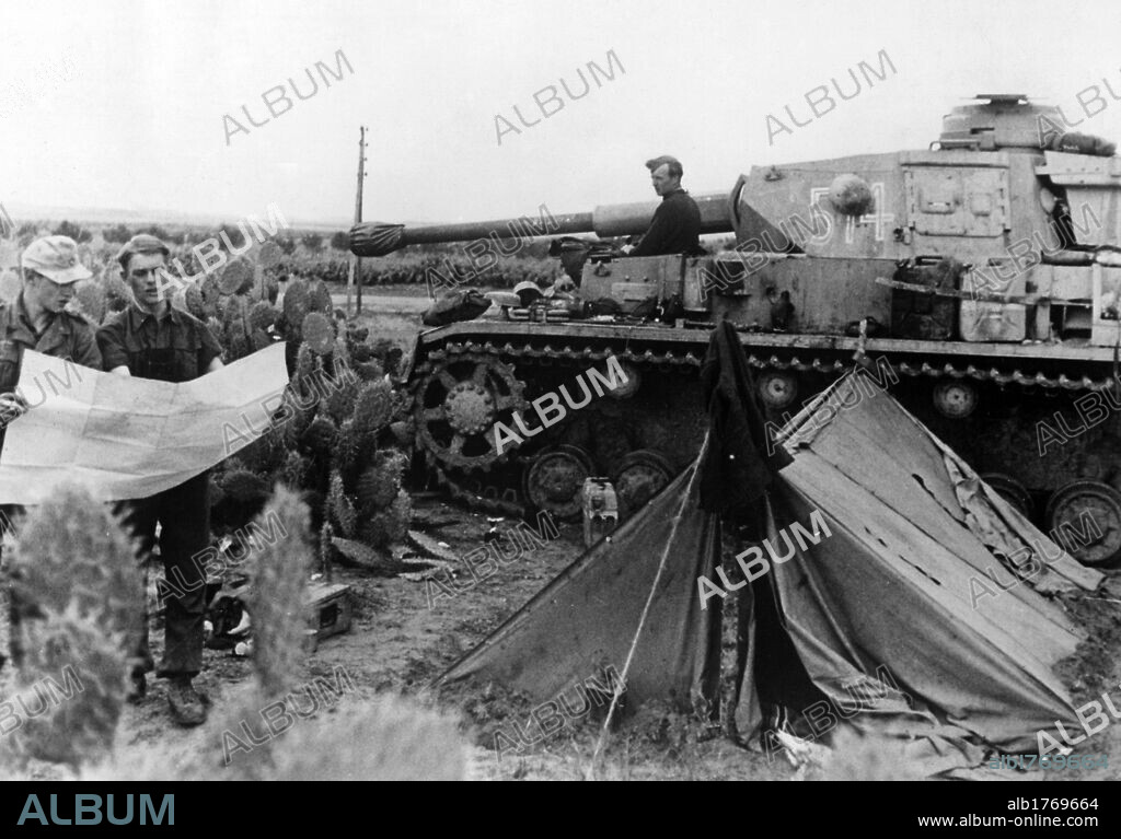 German tank parked at the Kasserine Pass. German tank parked at the Kasserine Pass near the crews tent, while two tank drivers consult a map. Tunisia, February 1943.