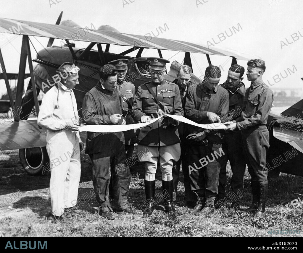 Maywood, Illinois: July 20, 1925. Army pilots check their maps during their transcontinental flight between Selfridge Airfiled in Harrison, Michigan and San Francisco, California. Behind them is one of the 5 Curtis P-! Hawks open cockpit biplane fighter aircrafts that they are flying.