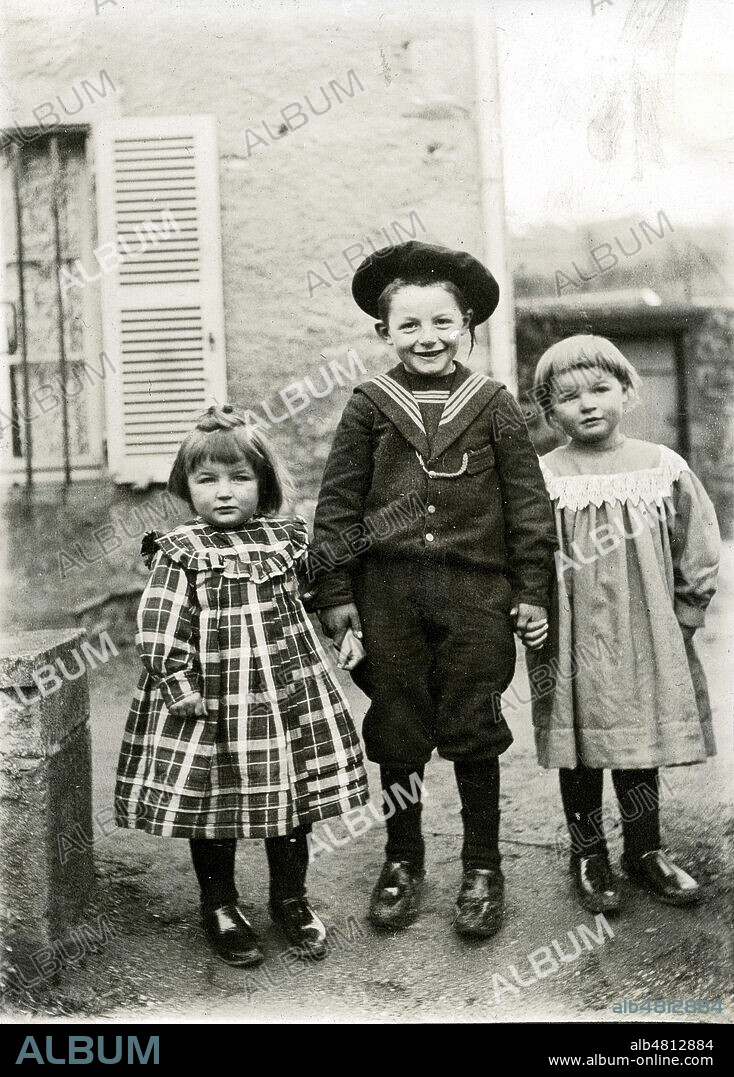 3 enfants vers 1900, milieu modeste a la campagne, le petit garcon porte un costume marin, une petite fille a la "coupe au bol", ils ont tous les trois des galoches . Photo de famille anonyme, collection privee. Credit Collection KHARBINE TAPABOR.