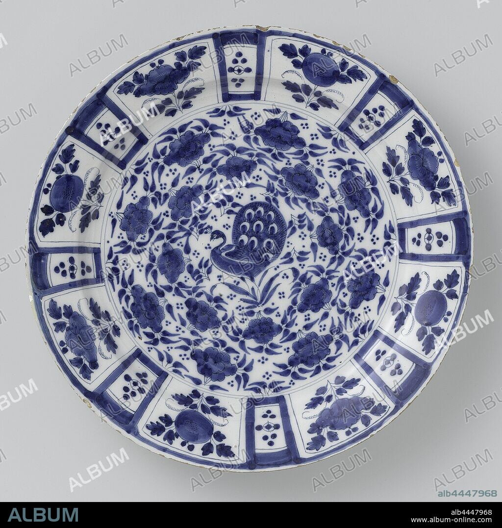 Dish of faience, dish of earthenware decorated in blue on a white ground. The border is divided into eight planes with flowers separated by eight smaller planes, each with nine dots, inspired by cracked porcelain. The shelf is decorated with flower and leaf motifs in two circles. A peacock can be seen in the middle. The border has star and circular motifs on the back., anonymous, Delft, c. 1700 - c. 1740, earthenware, d 39.5 cm × h 5.5 cm.