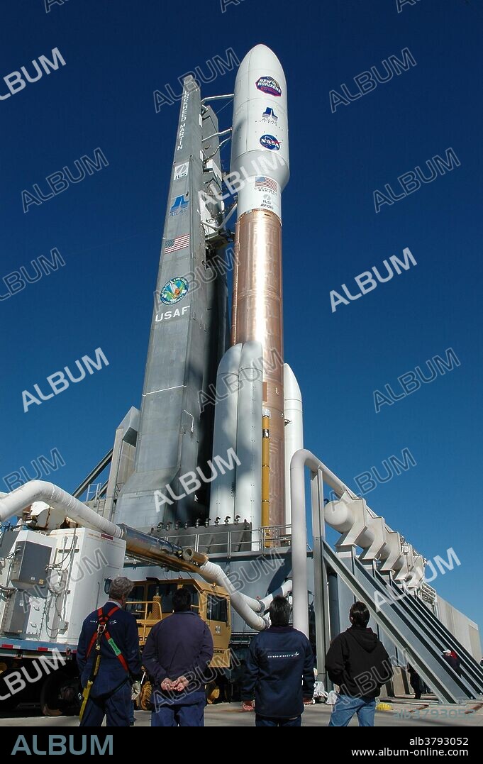 On Complex 41 at Cape Canaveral Air Force Station in Florida, workers take a moment to observe the Atlas V expendable launch vehicle with the New Horizons spacecraft poised for launch. It launched on Jan. 17, 2006. After its launch aboard the Atlas V, the compact, 1,050-pound piano-sized probe got a boost from a kick-stage solid propellant motor for its journey to Pluto. New Horizons is the fastest spacecraft ever launched, reaching lunar orbit distance in just nine hours. It passed Jupiter 13 months later.