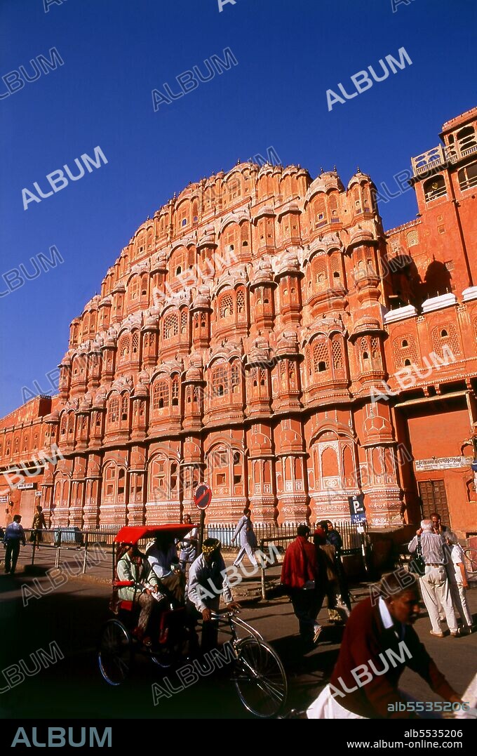 The Hawa Mahal was built in 1799 by Maharaja Sawai Pratap Singh, and designed by Lal Chand Ustad in the form of the crown of Krishna, the Hindu god. Jaipur is the capital and largest city of the Indian state of Rajasthan. It was founded on 18 November 1727 by Maharaja Sawai Jai Singh II, the ruler of Amber, after whom the city was named. The city today has a population of 3.1 million. Jaipur is known as the Pink City of India. The city is remarkable among pre-modern Indian cities for the width and regularity of its streets which are laid out into six sectors separated by broad streets 34 m (111 ft) wide. The urban quarters are further divided by networks of gridded streets. Five quarters wrap around the east, south, and west sides of a central palace quarter, with a sixth quarter immediately to the east. The Palace quarter encloses the sprawling Hawa Mahal palace complex, formal gardens, and a small lake. Nahargarh Fort, which was the residence of the King Sawai Jai Singh II, crowns the hill in the northwest corner of the old city. The observatory, Jantar Mantar, is a World Heritage Site.
