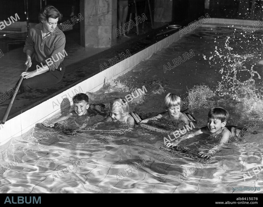 ARKIV STOCKHOLM 19560918. Simundervisning i Sportpalatset vid S:t Eriksbron i Stockholm. Asta Norman lär barnen Jonas Falk, Ann-Louise Wedin, Charlotte Wedin och Thomas Falk att simma. Foto: Alf Lidman / DN / TT / Kod: 4486. **SvD OUT**.
