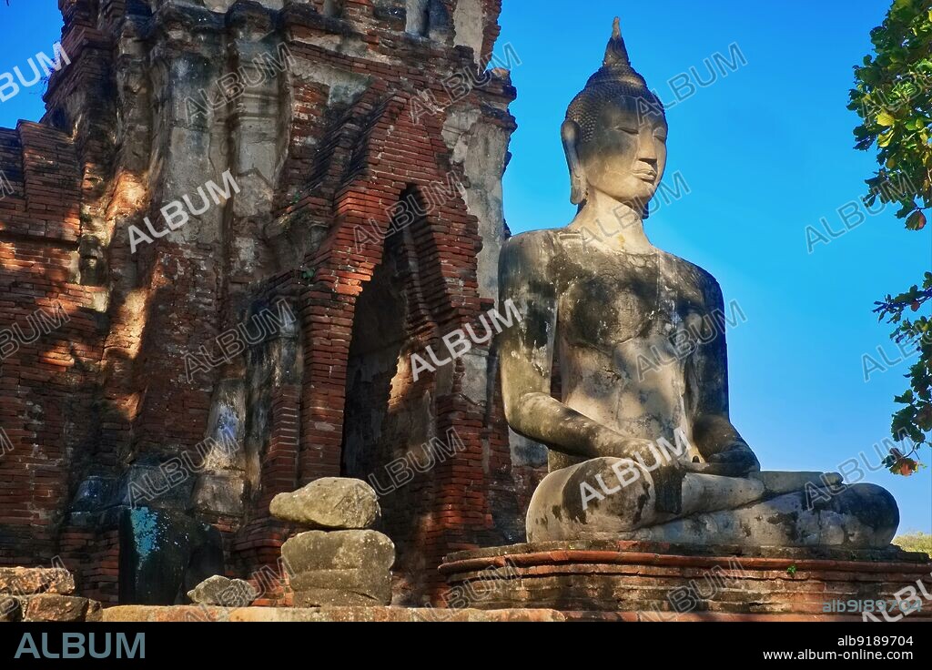 Thailand: A Buddha statue at Wat Mahathat (Wat Maha That) in Ayutthaya Historical Park in the former capital city of Ayutthaya. Wat Phra Mahathat was built during the reign of Borommaracha I (Boromma Rachathirat I) or Khun Luang Pa Ngua (1370- 1388), who was the third king of the Ayutthaya Kingdom. Ayutthaya (Ayudhya) was a Siamese kingdom that existed from 1351 to 1767. Ayutthaya was friendly towards foreign traders, including the Chinese, Vietnamese (Annamese), Indians, Japanese and Persians, and later the Portuguese, Spanish, Dutch and French, permitting them to set up villages outside the city walls.