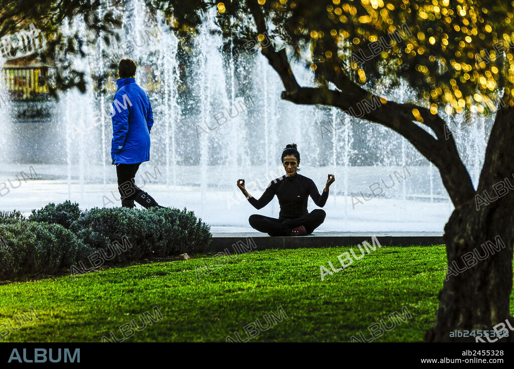 Woman practicing yoga, Riera Park, Palma, Mallorca, Balearic Islands, Spain.