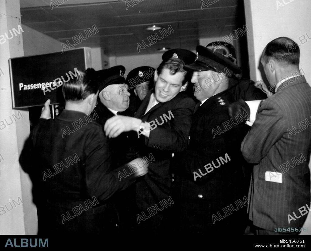 Johnny Ray Gets Mobbed - Again -- Getting mobbed by hysterical fans (mainly women) is no new experience for American singer Johnny Ray. Police had to patrol the London Palladium for over three hours during his farewell performance there on Saturday evening and in Edinburgh the following day he was again set upon by admirers who ***** him into his hotel. When this picture was taken Johnny was just getting away from some more fans at London Airport with the aid of police and airport officials. May 9, 1955. (Photo by Daily Express Picture).