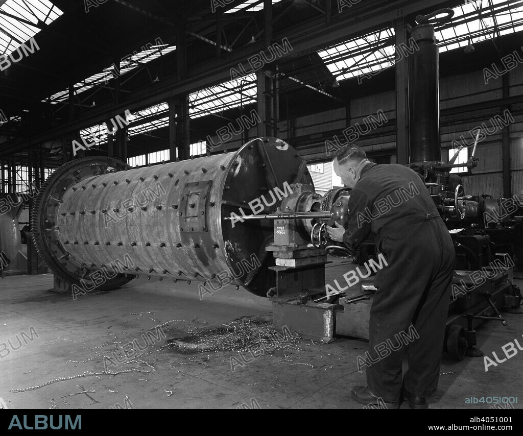 Using an industrial drill during the fabrication of a ball mill, Sheffield, South Yorkshire, 1963. An engineer using an industrial drill during the fabrication of a ball mill at the Edgar Allen Steel Co in Sheffield. Ball mills are used to grind or mix materials like ores, chemicals, ceramic raw materials and paints. They rotate around a horizontal axis, partially filled with the material to be ground plus the material that does the grinding. This can be ceramic or stainless steel balls, flint pebbles or similar materials. The cascading effect reduces the material to a powder.
