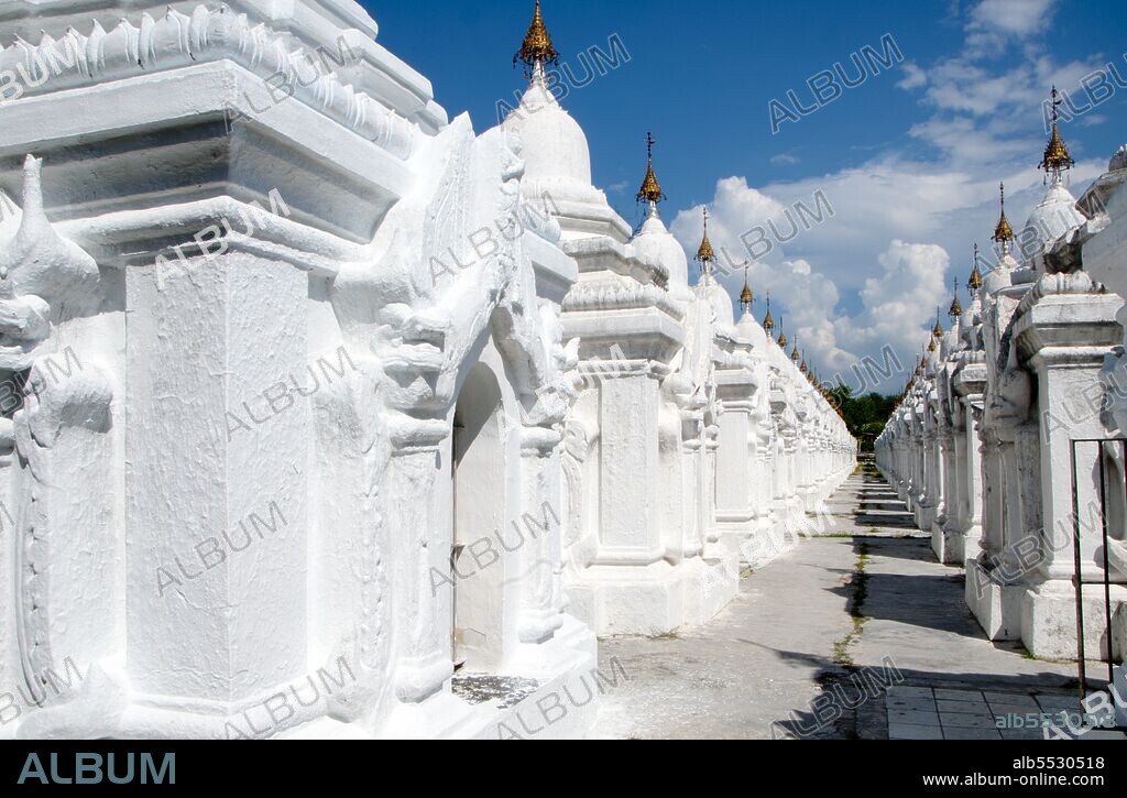 The entire Tipitaka Pali canon of Theravada Buddhism is set on 729 marble slabs, each with 80 to 100 lines of text, originally in gold ink, on both the obverse and the reverse sides. Each stone is three and a half feet wide, five feet tall and five inches thick and housed in a <i>kyauksa gu</i> or a small cave-like stupa. Kuthodaw Pagoda, literally meaning Royal Merit Pagoda, and formally titled Mahalawka Marazein, is a Buddhist temple and stupa located in Mandalay, central Burma. It lies at the foot of Mandalay Hill and was built during the reign of King Mindon (1808—78). The stupa itself, which is gilded above its terraces, is 57 m (188 ft) high, and is modelled after the Shwezigon Pagoda at Nyaung-U near Bagan. In the grounds of the pagoda are 729 'kyauksa gu' or stone-inscription caves, each containing a marble slab inscribed on both sides with a page of text from the Tipitaka, the entire Pali Canon of Theravada Buddhism. The stone inscriptions are considered to be the largest book in the world. Mandalay, a sprawling city of more than 1 million people, was founded in 1857 by King Mindon to coincide with an ancient Buddhist prophecy. It was believed that Gautama Buddha visited the sacred mount of Mandalay Hill with his disciple Ananda, and proclaimed that on the 2,400th anniversary of his death, a metropolis of Buddhist teaching would be founded at the foot of the hill.