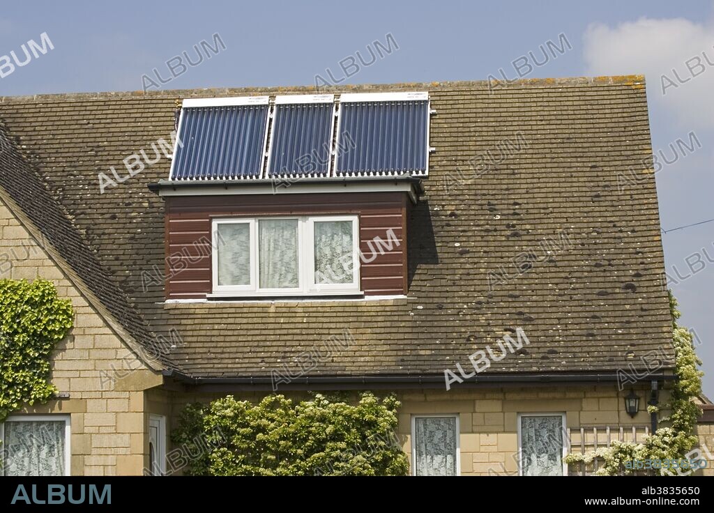 Modern solar panels on the roof of a detached house, Cotswolds, UK.