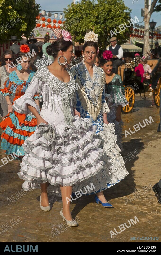 April Fair, Young women wearing a traditional flamenco dress, Seville, Region of Andalusia, Spain, Europe.