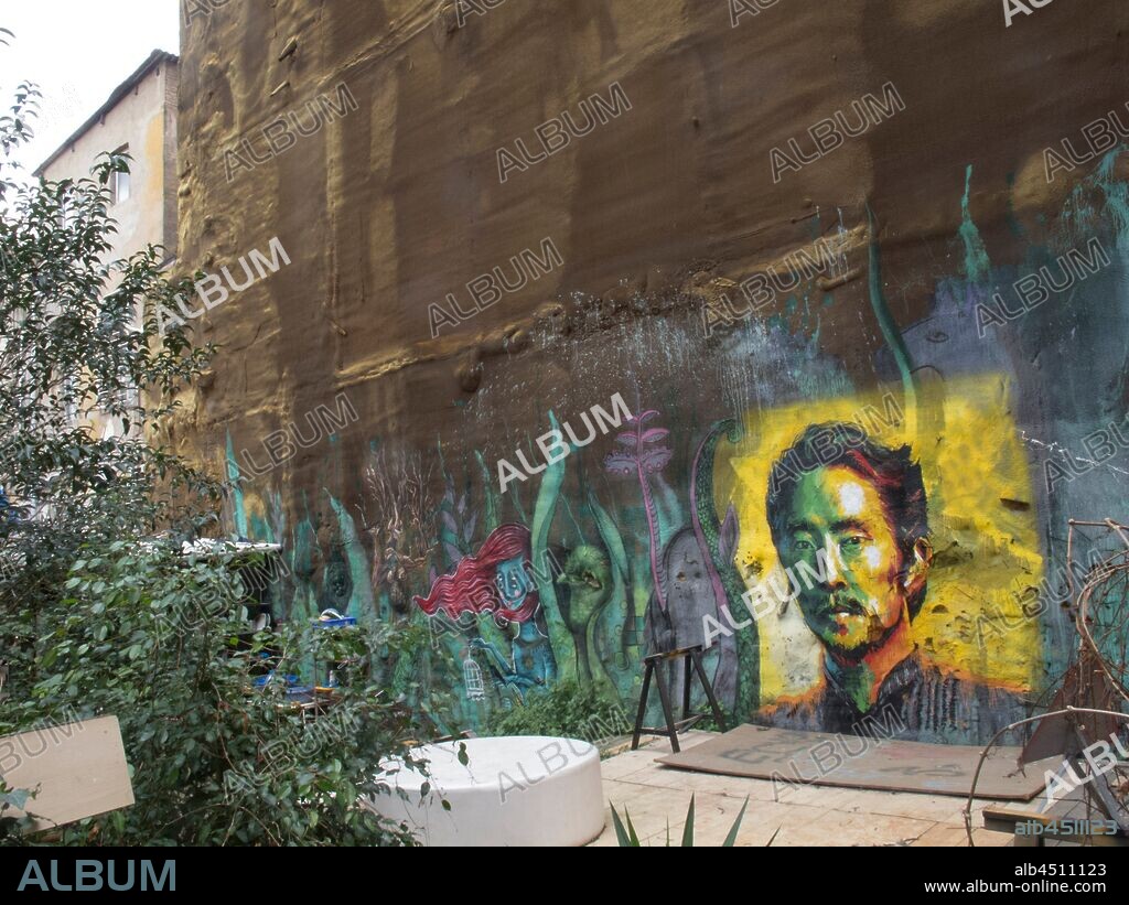 Pintura retrato de hombre oriental con fondo amarillo, graffiti mural, barrio Raval, Distrito V, Barcelona en 2016.