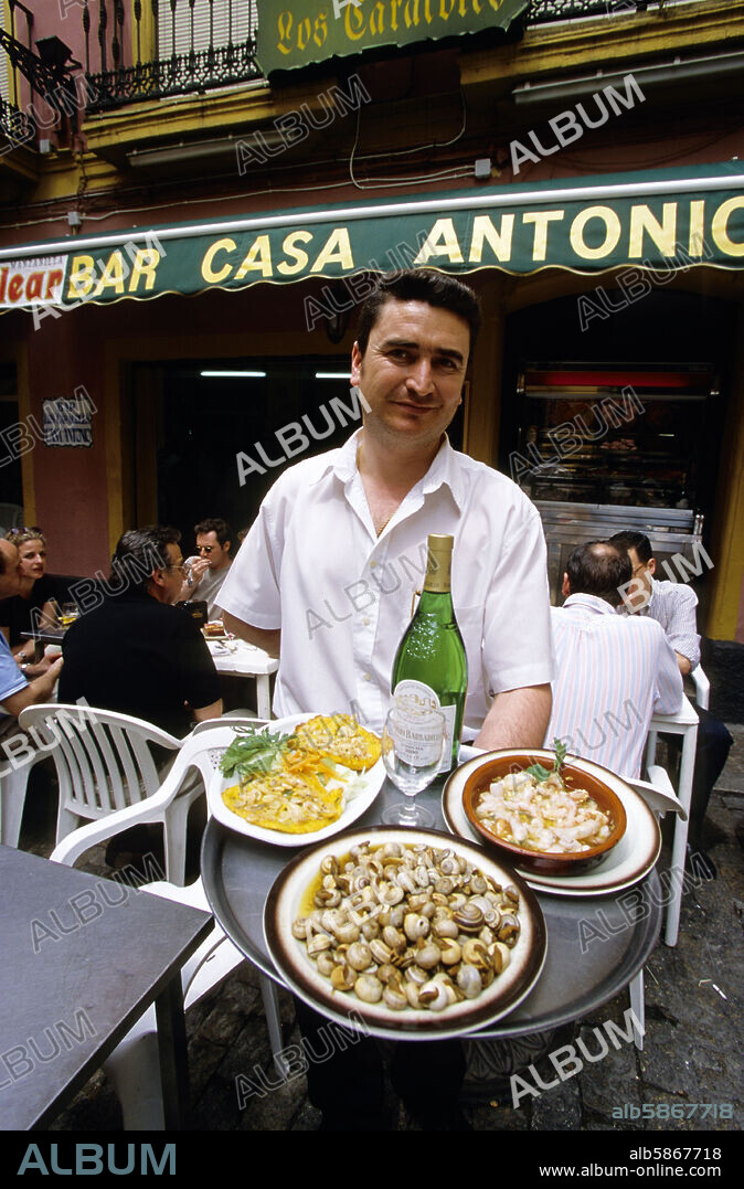 Bar "Antonio-Los Caracoles"; camarero con tapas de caracoles, coquinas y tortilla de camarones.