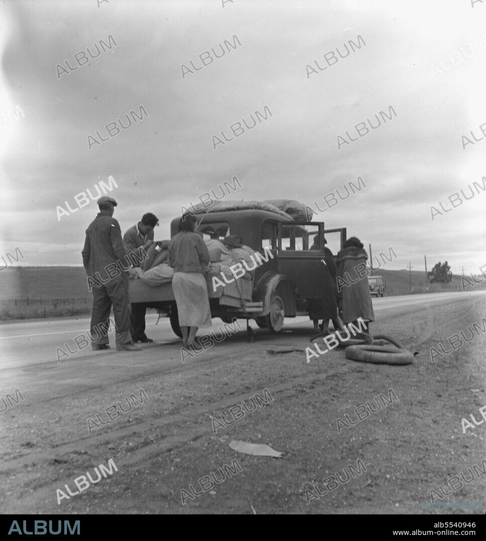 DOROTHEA LANGE. Migrants, family of Mexicans, on road with tire trouble. Looking for work in the peas. California.