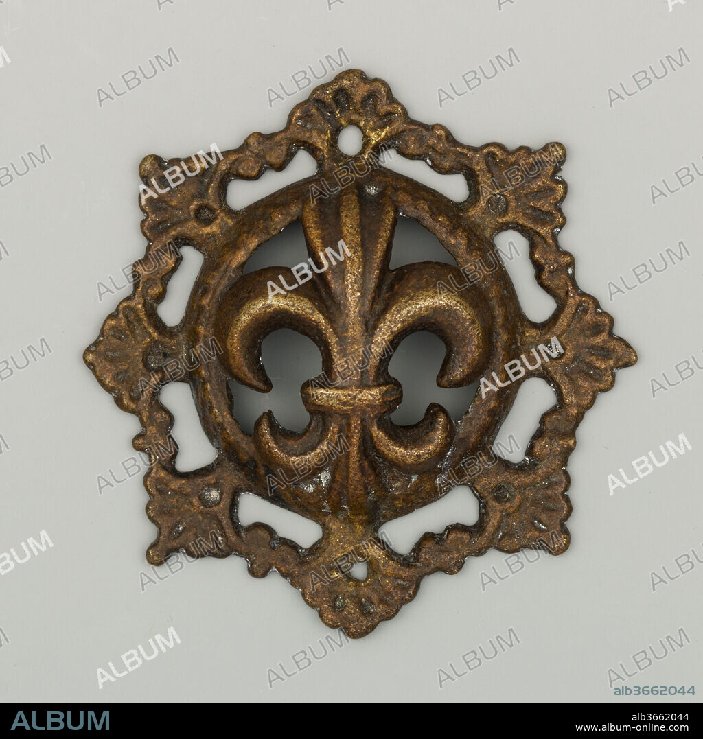 Bit Boss. Culture: probably Netherlandish. Dimensions: Diam. 3 5/16 in. (8.4 cm); Wt. 3 oz. (86 g). Date: first half 17th century.
Bit bosses were ornamental elements decorating both sides of a horse bit. The center of this boss is adorned with an openwork fleur-de-lis circled by a wreath, while the rim displays a frieze of palmettes.
This object belongs to a large group of bosses using a series of rims and centers combined in different ways. The exact center of production of these bosses is still unclear. If the motifs used are Italian, the scale of the production and the process of combining a series of rims and center recalls contemporary German practices. Some of them, however, are identical or very similar to bosses seen in several early 17th-century Netherlandish paintings, a likely origin for the manufacture of these objects.