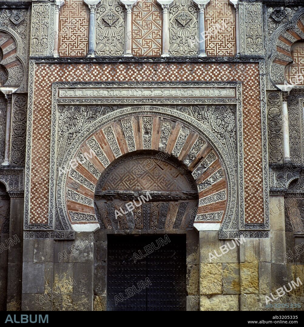 MEZQUITA DE CORDOBA. PUERTA DE LA FACHADA OESTE. ARCO POLILOBULADO EN ROJO Y BLANCO Y A AMBOS LADOS DE LA PUERTA, EN LA PARTE SUPERIOR, DOS CELOSIAS BLANCAS.  CORDOBA, ESPAÑA.
