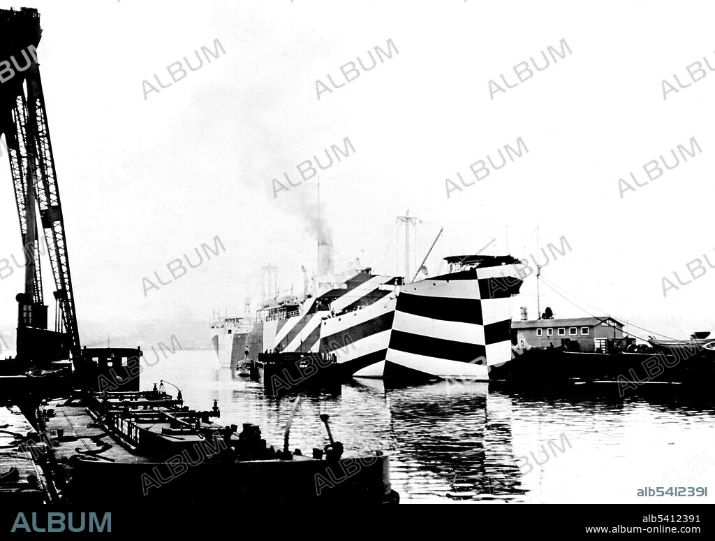 USS West Mahomet in port, 1918, her dazzle camouflage greatly distorts the apparent aspect of her bow. Dazzle camouflage was a family of ship camouflage used extensively in WWI, and to a lesser extent in WWII and afterwards. Credited to the British marine artist Norman Wilkinson it consisted of complex patterns of geometric shapes in contrasting colors, interrupting and intersecting each other. The intention of dazzle was not to conceal but to make it difficult to estimate a target's range, speed, and heading. (cropped and cleaned).