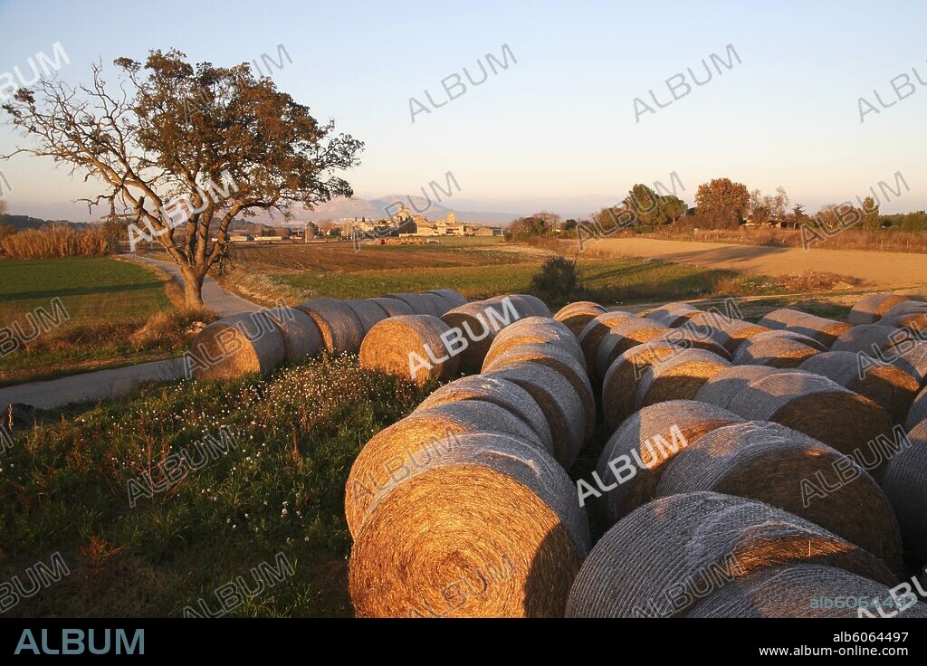 Vullpellac; vista del pueblo y balas de paja al atardecer.