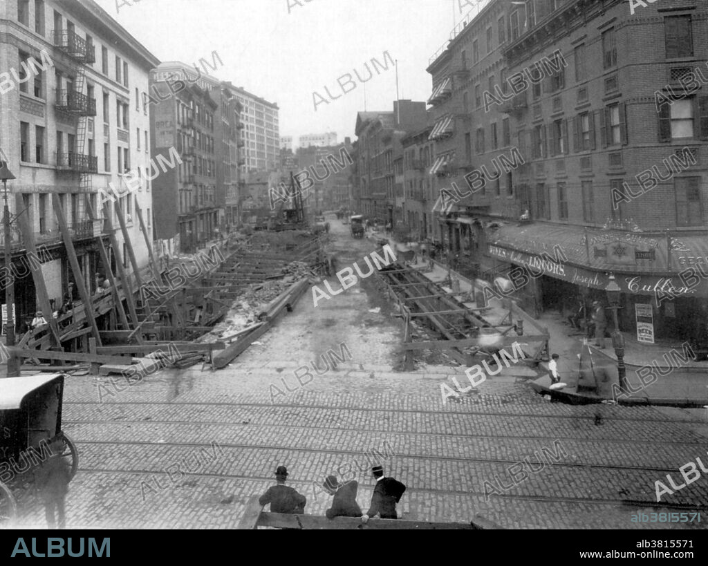 Life around construction of NYC first subway was extremely disruptive. Many shopkeepers went bankrupt since people were afraid to go near the excavations and heavy machinery. During construction, the foundations of several buildings were undermined. Note the heavy timbers shoring up the white corner building on the left. The New York City Subway is a rapid transit system owned by the City of New York and leased to the New York City Transit Authority. Opened in 1904, the New York City Subway is one of the world's oldest public transit systems, one of the world's most used metro systems, and the metro system with the most stations and the most trackage. It offers service 24 hours per day and every day of the year. The Lexington Avenue Line is one of the lines of the IRT division of the New York City Subway, stretching from Downtown Brooklyn or Lower Manhattan north to 125th Street in East Harlem. Photograph taken at the corner of Elm (Lafayette) and Spring Streets, July 8, 1901.
