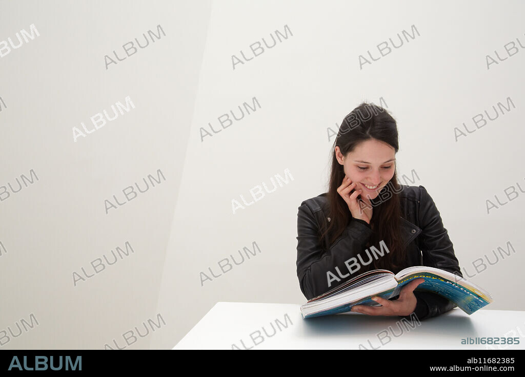 Young woman looking at exhibition catalog. David Hockney, ¥A Bigger Picture¥ exhibition, Guggenheim Museum, Bilbao, Biscay, Basque Country, Spain.