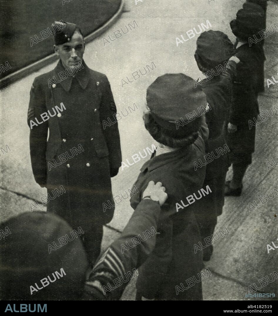 'R.A.F. Sergeant Drills Airwomen', c1943. The Women's Auxiliary Air Force (WAAF), whose members were referred to as 'WAAFs', was the female auxiliary of the British Royal Air Force during World War II. Its members did not serve as aircrew, but although they did not participate in active combat, they were exposed to the same dangers as any on the home front working at military installations. Among their duties were: crewing of barrage balloons, catering, meteorology, radar, aircraft maintenance, transport, communications duties including wireless telephonic and telegraphic operation. At its peak strength, in 1943, the number of WAAFs (members of the force) exceeded 180,000, with over 2,000 women enlisting per week. From "Wings On Her Shoulders", by Katharine Bentley Beauman, Late Fight Officer W.A.A.F. [Hutchinson & Co Ltd, London, New York, Melbourne, c1943].