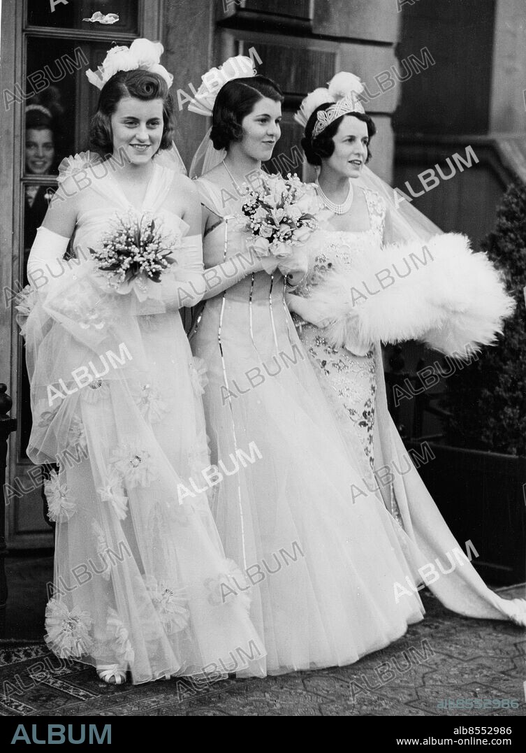 Orig. bildtext... U.S. AMBASSADOR'S WIFE PRESENTS HER DAUGHTERS AT COURT. 12.5.38. Kathleen and Rosemary Kennedy , daughters of Mr. Joseph Kennedy, the U.S. Ambassador to London, were amonh the debutantes presented at the first Court of the season, at Buckingham Palace last night. O.P.S. (l to r) Kathleen; Mrs. Kennedy and Rosemary, photographed before leaving for Buckingham Palace yesterday evening. Anm. R Kennedy, 1890-1995, gift med J P Kennedy. Kathleen, 1920-1948. Rosemary, 1918-2005. Trio Tiaror Galastass Blombuketter Klänningar Handskar Döttrar Aftonklänningar Brokad Tyll Svandun Fester CD670 persons: ROSEMARY KENNEDY;KATHLEEN KENNEDY;ROSE KENNEDY sites: LONDON;STORBRITANNIEN;USA*.