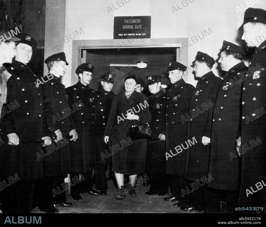 Guard For Anna Strong -- Anna Louise Strong, author expelled, from Russia on espionage charges, walks through police ranks as she arrives at La Guardia field today. The American writer denied any spying. She was met at the airport by FBI agents who handed her a subpoena to appear tomorrow before a federal grand jury which has been looking into Communism and espionage matters. February 24, 1949. (Photo by AP Wirephoto).