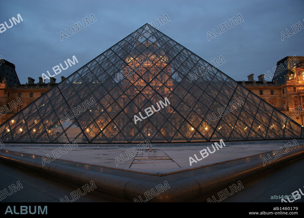 Louvre Museum. Facade of the building and glass pyramid, at night. The piramids was designed by the architect Leo Ming Pei, in 1981.  Paris. France. Europe.