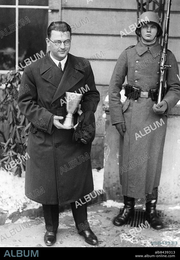 TYSKLAND BERLIN 1932-02-27. Orig. bildtext... Reichspräsident von Hindenburg überreichte am 27.2 dem bekannten Flieger Wolfram Hirth den Hindenburg-Preis für hervorragende Leistungen auf dem gebiete der Segelfliegerei. 41943) Wolfgang Hirth mit dem Ehrenpokal nach dem Empfang beim Reichspräsidenten. Foto: Robert Sennecke / AB Text & Bilder / SVT / Kod: 5600 Mapp: Hirth, Wolfram "Wolf" W Hirth, 1900-1959, tysk ingenjör och segelflygspionjär Segelflyg Priser Pokaler persons: WOLFRAM HIRTH;WOLF HIRTH sites: TYSKLAND;BERLIN.
