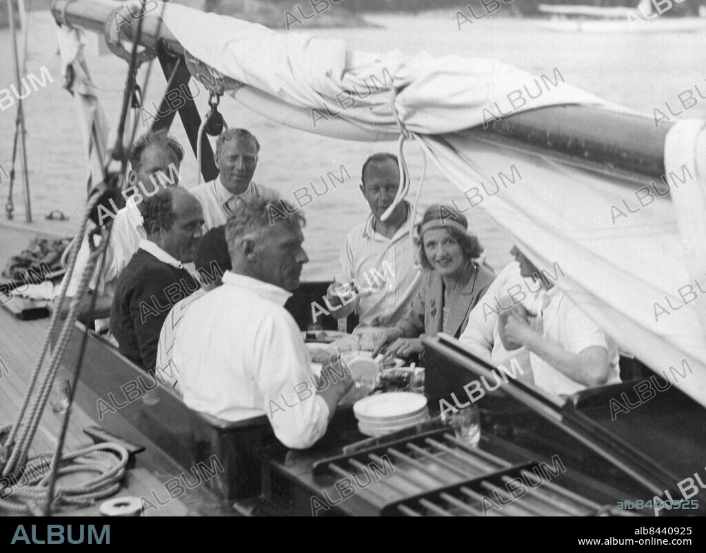 1930-tal.. Utan bildtext. Not. Lunch på Wallenbergs båt. Furstinnan Bissmarck (under en Sandhamnsregatta i början på tretti-talet...) Anm. J Wallenberg, 1892-1980, svensk bankman. A-M Tengbom von Bismarck, 1907-1999, gift med prins Otto von Bismarck II. Segel Segelbåtar Bom Sittbrunn Tallrikar Profiler Hårband CD502 persons: ANN-MARI TENGBOM VON BISMARCK;JACOB WALLENBERG sites: SVERIGE.