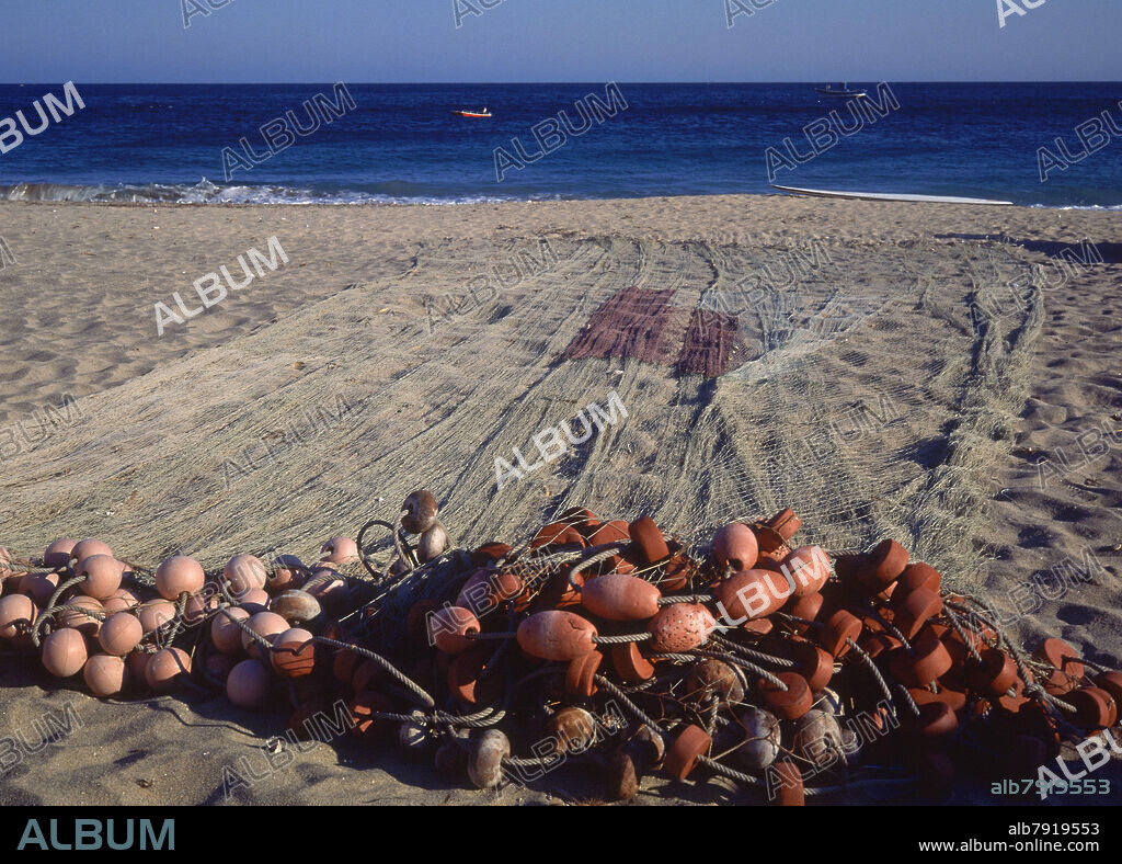 REDES DE PESCA CON BOYAS EN LA PLAYA -AL FONDO EL MAR-.