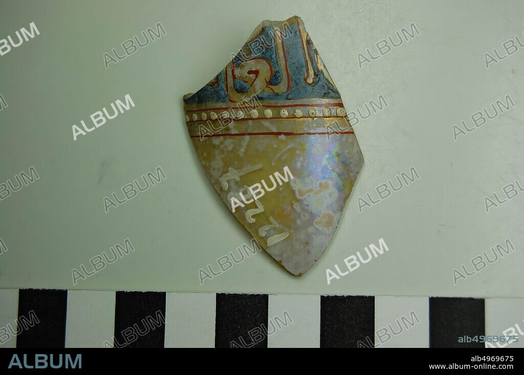 Glass shard with the colors red, blue and gold. Small white dots embossed. In the glass air bubbles. Surface area. Old number: 12287., shard, glass, 5 x 4 cm, Roman 50-100, Egypt.